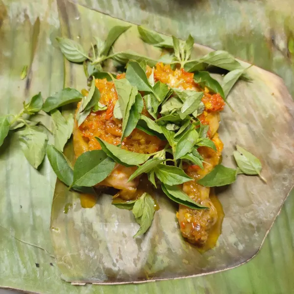 Siapkan daun pisang yang sudah di jemur dan di bersihkan, tata ayam, kemangi dan bumbu, lipat daun pisang, kemudian kukus selama 20 menit.