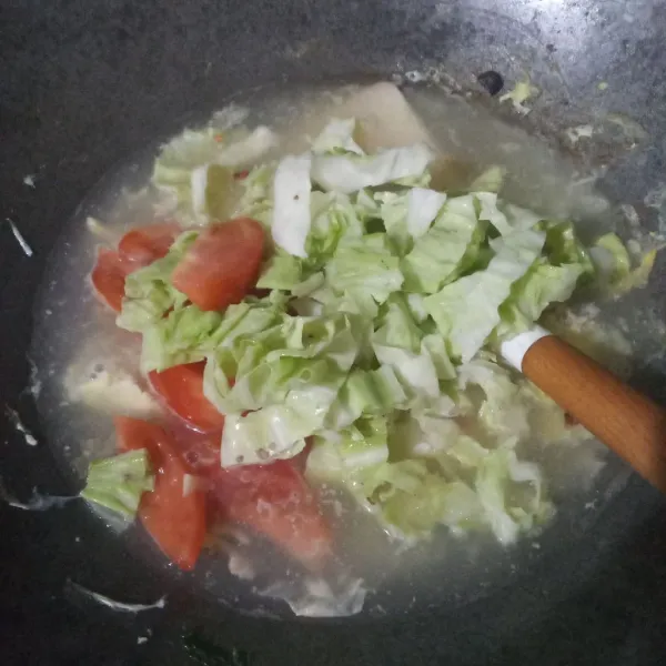 Tuang air, biarkan mendidih lalu masukkan gubis dan tomat. Masak hingga setengah matang.