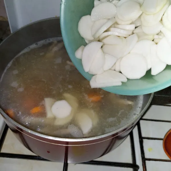 Masukkan wortel dan lobak ke dalam rebusan ceker.