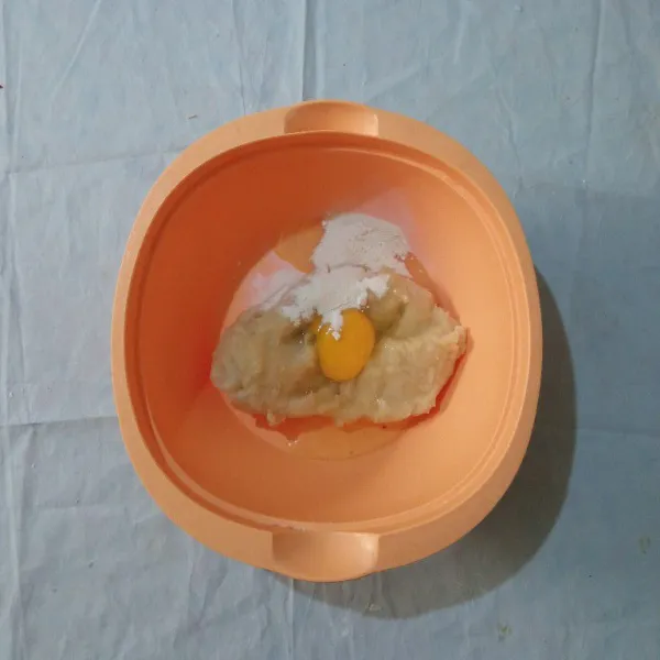 Pindahkan adonan biang ke dalam wadah, lalu tambahkan telur dan bubuk bawang putih.