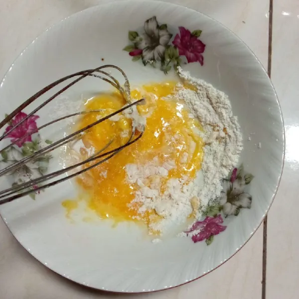 Campur kuning telur, air, dan tepung terigu. Aduk sampai tercampur rata lalu sisihkan.