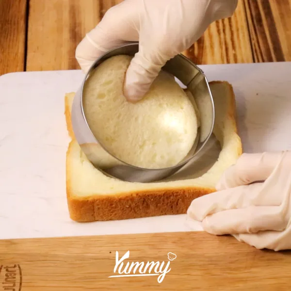 Siapkan roti tawar, potong bagian tengah roti dengan ring cutter, sisihkan.