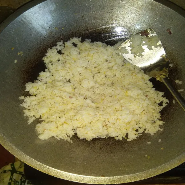 Masukkan nasi putih dan tambahkan kaldu bubuk non MSG, lalu aduk rata dan cicipi rasanya sampai pas.