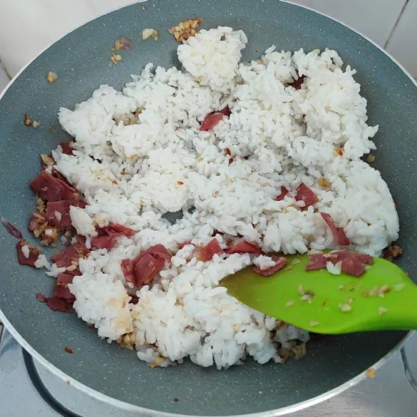 Masukkan nasi putih, aduk rata.