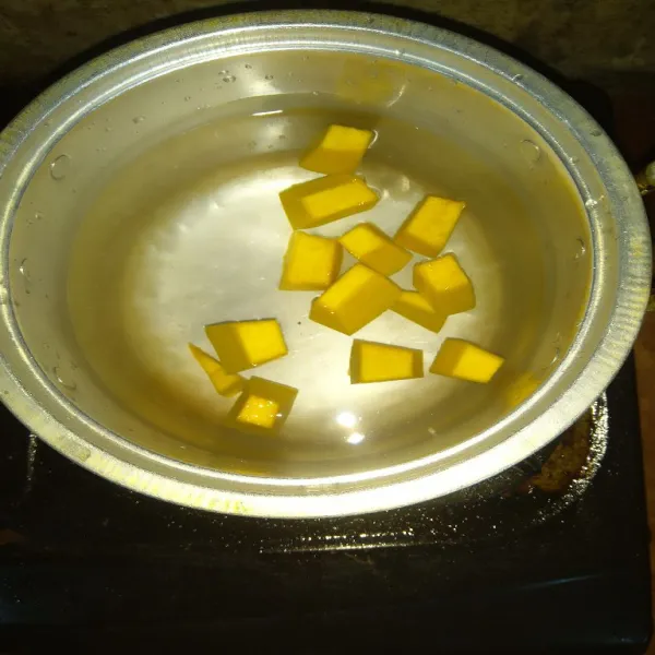 Rebus air, kemudian masukkan potongan labu kuning. Masak sampai 1/2 matang.