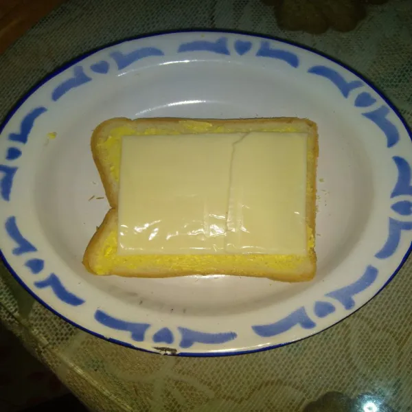 Beri keju slice di atasnya, lalu tutup dengan roti lainnya.
