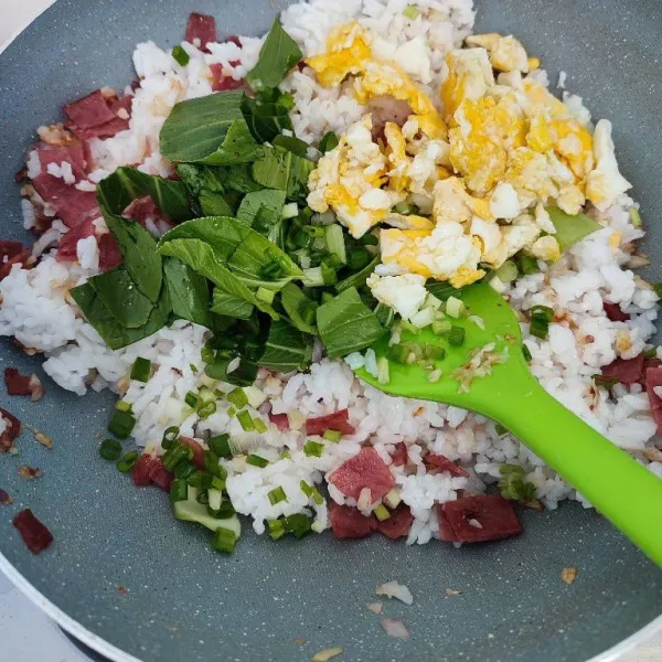 Tambahkan pokcoy dan telur orak arik. Masak hingga pokcoy layu.