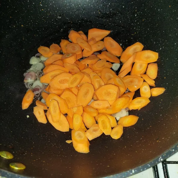 Masukkan wortel, aduk rata hingga layu.