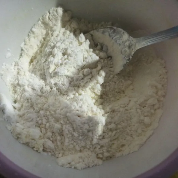 Campur jadi satu tepung terigu, susu bubuk, tepung maizena, dan vanili, lalu aduk rata. Kemudian ayak.
