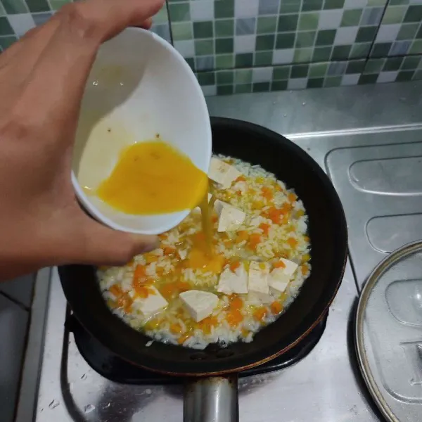 Setelah air berkurang setengahnya, masukkan telur yang dikocok lepas, aduk rata.
