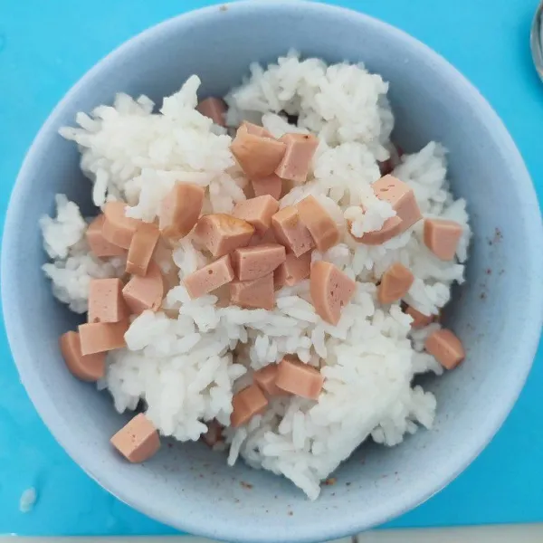 Masukkan nasi putih dan potongan sosis. Kemudian aduk hingga tercampur rata.