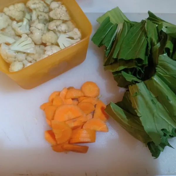 Potong-potong bunga kol wortel, sosis dan sawi, cuci bersih.