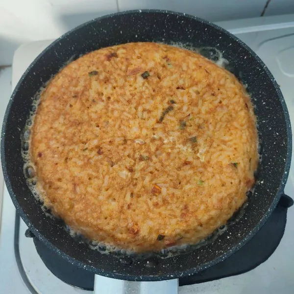 Balik omelette dengan bantuan piring datar. Masak kembali hingga bagian bawah matang.
