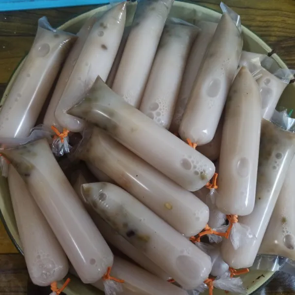 Masukkan 1-2 sdt kacang hijau kedalam plastik es lilin kemudian tuang kuah es dan ikat dengan karet.