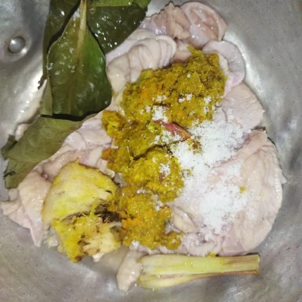 Lalu masukkan kulit ayam ke dalam panci, tambahkan bumbu halus, garam, serai, lengkuas dan daun salam.