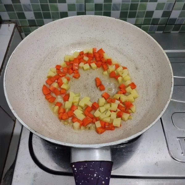 Kemudian masukkan kentang dan wortel, aduk rata. Tumis sebentar hingga sedikit layu.