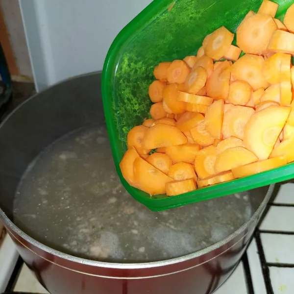 Masak wortel dalam kuah kaldu.