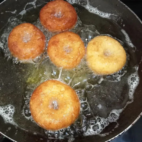 Panaskan minyak lalu goreng donat (sebelum masuk minyak lubangi bagian tengah donat dengan jari) goreng donat hingga kuning kecokelatan.