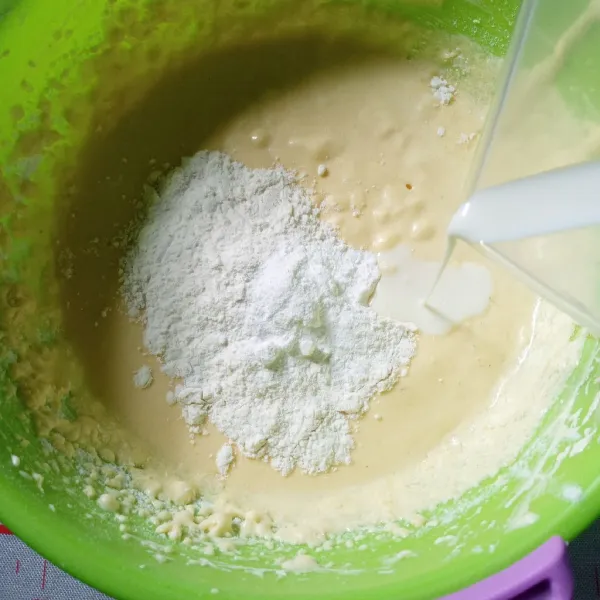 Pindahkan ke kecepatan paling rendah, masukkan tepung terigu bertahap, berselang-seling dengan susu cair. Matikan mixer, aduk menggunakan spatula, sebentar saja.