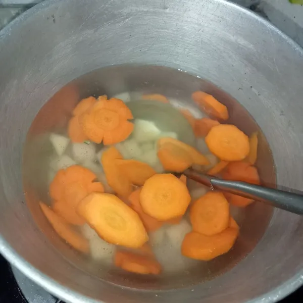 Rebus air untuk kuah hingga mendidih lalu masukkan wortel dan kentang.