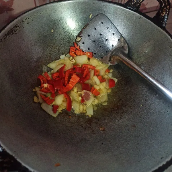 Tumis bawang putih dan bawang bombai sampai harum, selanjutnya masukkan cabai merah, masak hingga layu.
