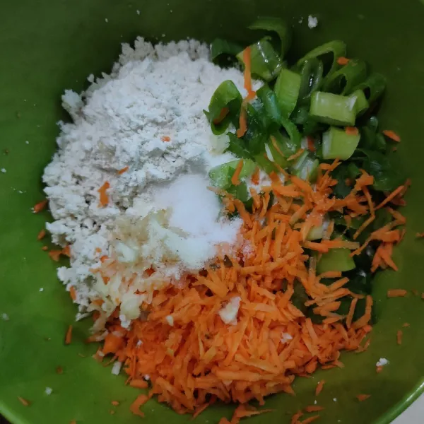 Masukkan tepung terigu, daun bawang, wortel, bawang putih, garam, kaldu bubuk dan lada bubuk.