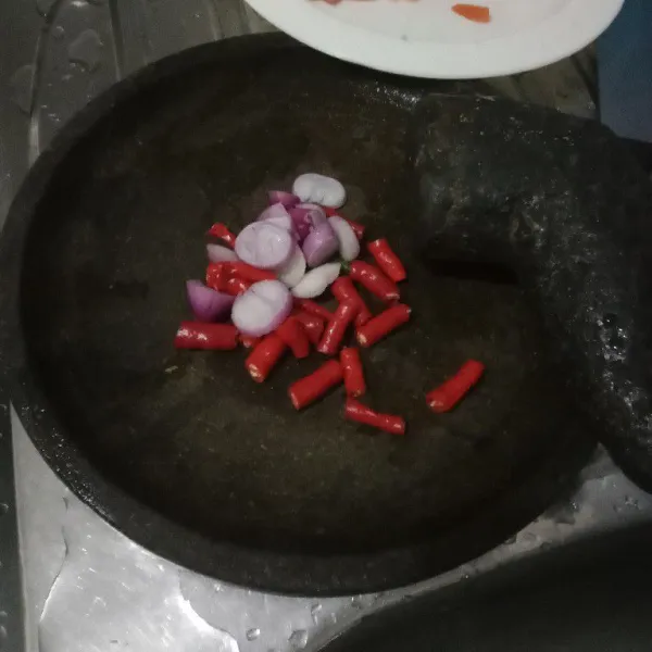 Ulek cabe dan bawang lebih dulu. Beri garam dan gula pasir agar lebih mudah menguleknya.