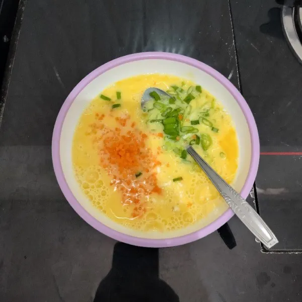Kocok lepas telur dalam mangkuk. Lalu tambahkan wortel dan daun bawang. Aduk rata.