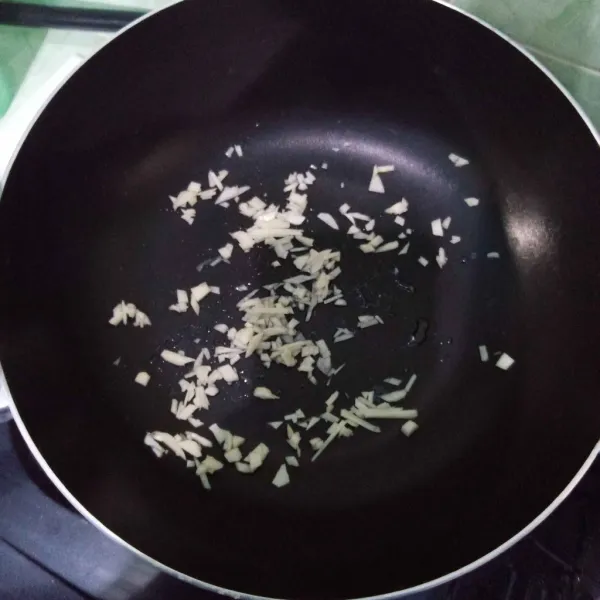 Tumis bawang putih cincang hingga harum.