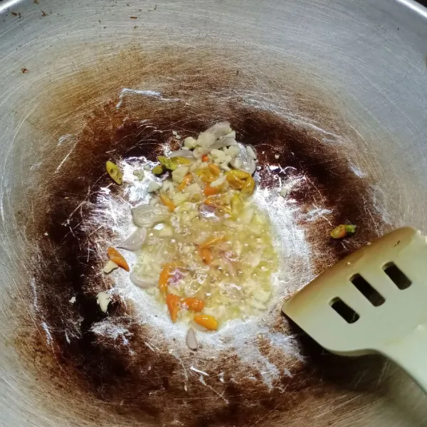 Panaskan minyak, tumis bawang merah, bawang putih dan cabe rawit sampai harum.