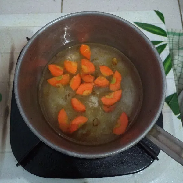 Didihkan air, masukkan wortel dan kentang, rebus sampai setengah matang.