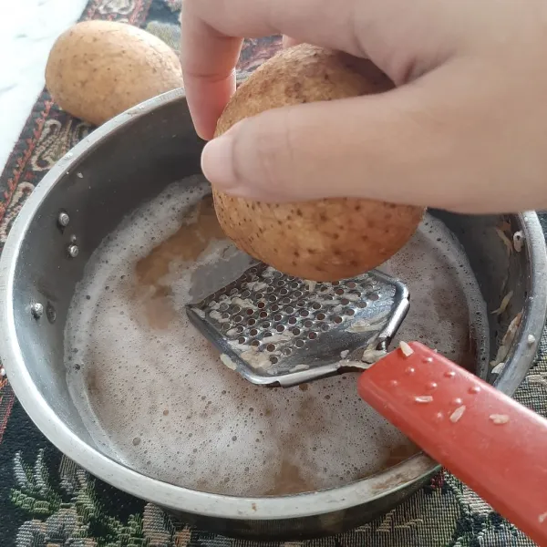 Cuci bersih kentang dan parut, masukkan dalam rendaman air.