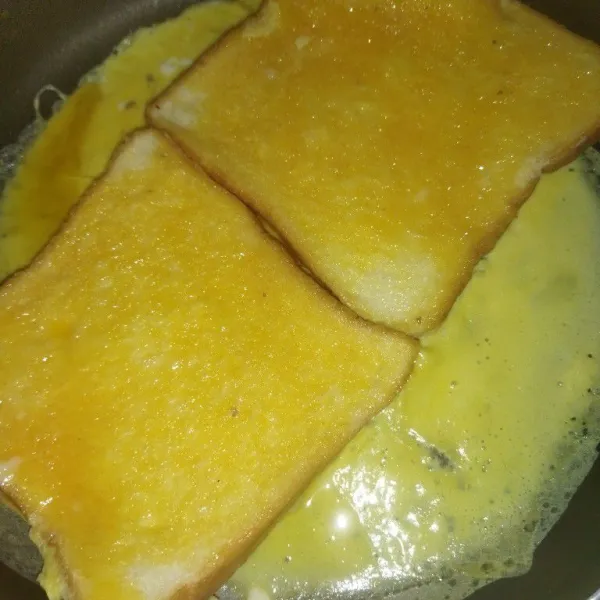 Lalu balik ke dua lembar roti tawar, masak hingga bagian bawah telurnya matang.