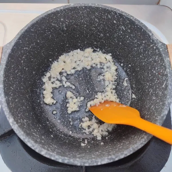 Sambil menunggu daging empal empuk, tumis bawang putih cincang hingga harum dan agak kecoklatan.