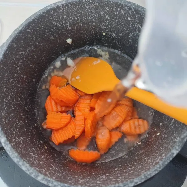 Masukkan irisan wortel dan 200 ml air. Rebus hingga wortel empuk.