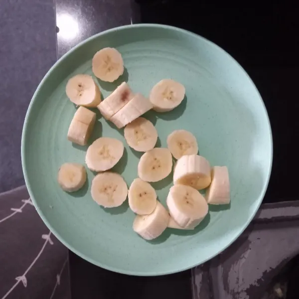 Kupas pisang lalu potong bulat, besarnya sesuai selera.