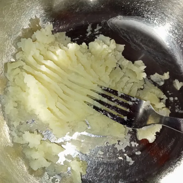 Haluskan kentang yang sudah dikukus menggunakan garpu.