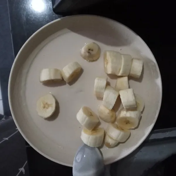 Lalu masukkan potongan pisang ke dalam adonan tepung, aduk rata, pastikan pisang terbalut tepung.