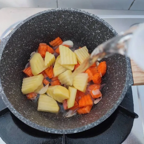 Tambahkan potongan wortel, potongan kentang dan 300ml air. Rebus hingga keduanya empuk.