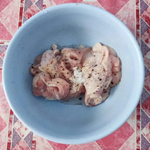 Marinasi ayam dengan garam, merica bubuk, kaldu ayam bubuk dan lada hitam cincang selama 10 menit.