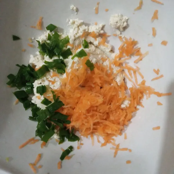 Masukkan wortel serut dan daun bawang.