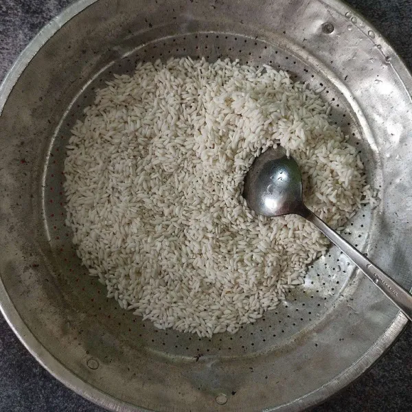 Setelah beras ketan direndam dua jam kemudian tiriskan airnya, lalu beri garam, aduk rata.