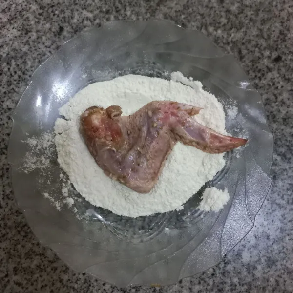 Lumuri ayam dengan sedikit air, lalu gulingkan pada adonan tepung, pastikan tepung menempel pada ayam.