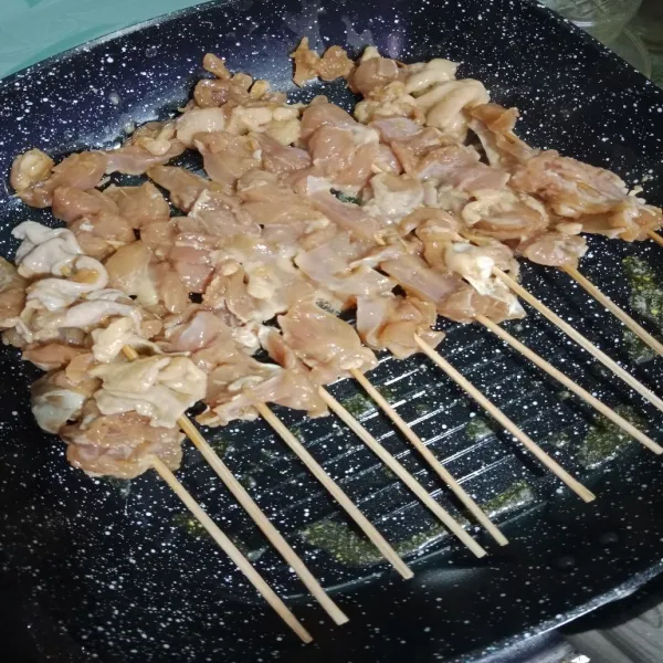 Oles grill pan dengan margarin. Panggang sate, bolak balik hingga matang dan ke coklatan.