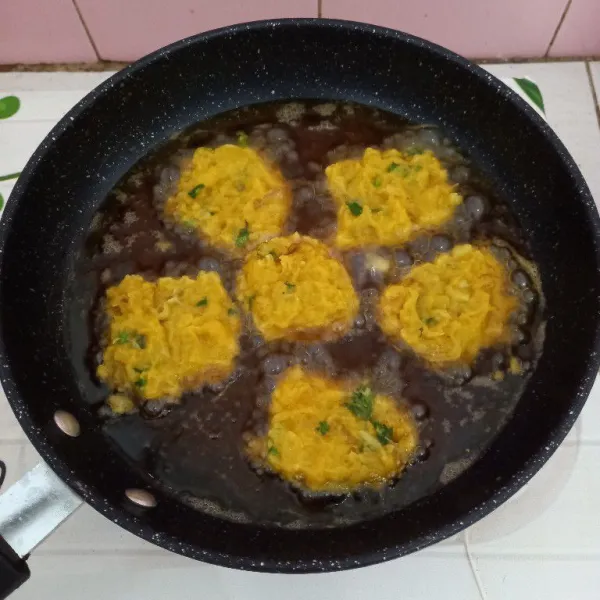 Goreng perkedel kentang di minyak panas sampai matang dan siap disajikan.