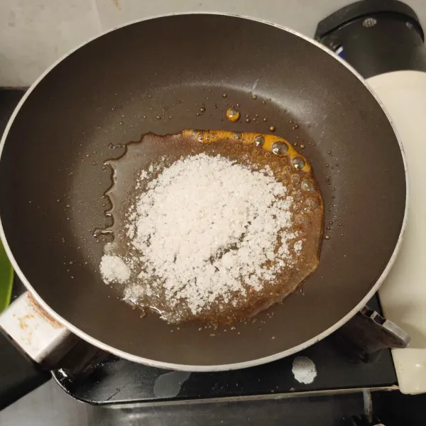 Membuat salted karamel, tuang gula ke pan anti lengket, gunakan api kecil hingga gula mencair.