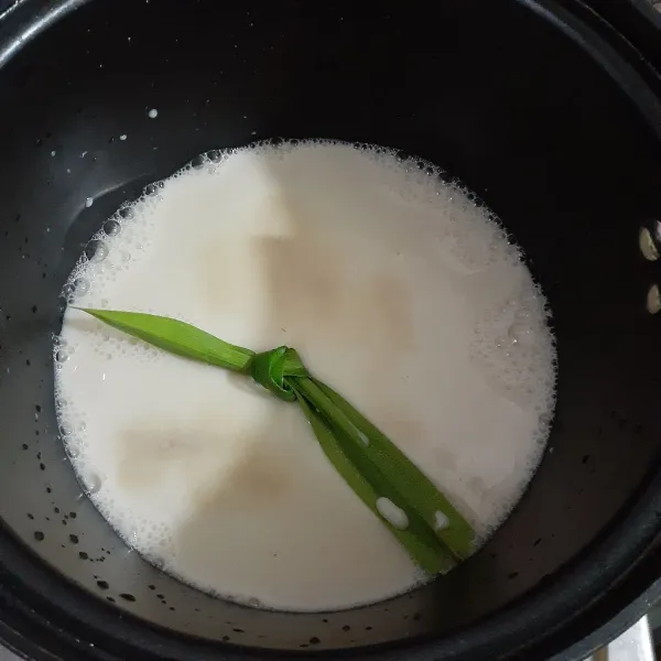 Pada panci, tuangkan susu kedelai, agar - agar dan daun pandan wangi, aduk rata.