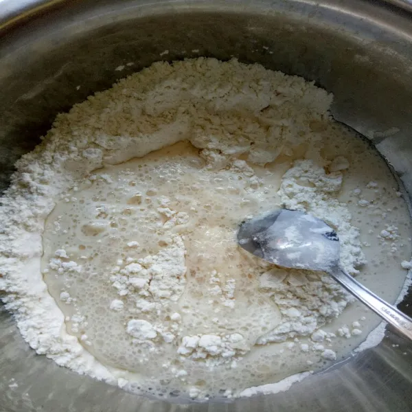 Dalam wadah lain, campur jadi satu, tepung terigu dan garam. Selanjutnya tuang biang ke dalam wadah tepung, aduk rata.