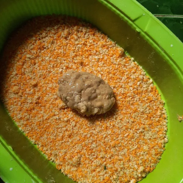 Guling gulingkan tempe di atas tepung roti sampai terbalut di semua sisi tempe.