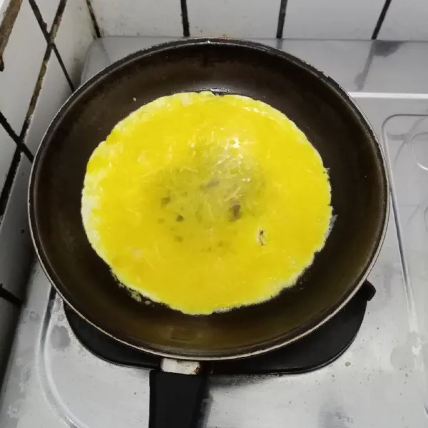 Lelehkan margarin. Tuang kocokan telur di teflon.